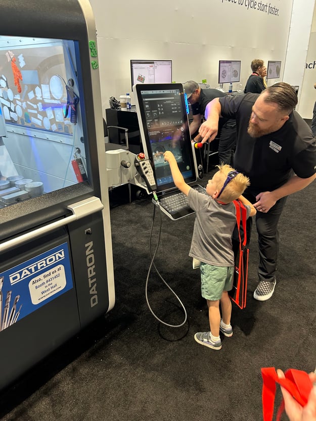 Kid programming a Datron at the booth